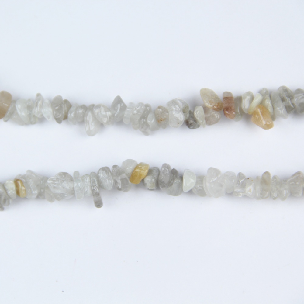 Create stunning, earthy designs with these Pink Rutilated Quartz Chip Beads. These natural gemstone chips feature golden or silver rutile inclusions within clear quartz, ideal for adding texture and elegance to custom jewelry such as necklaces, bracelets, and earrings.