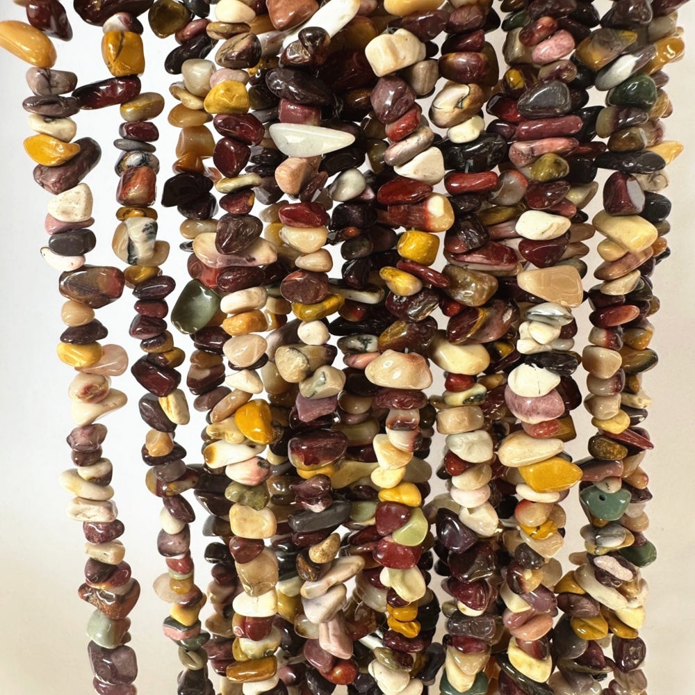 Close-up view of natural mookaite gemstone chips with polished texture